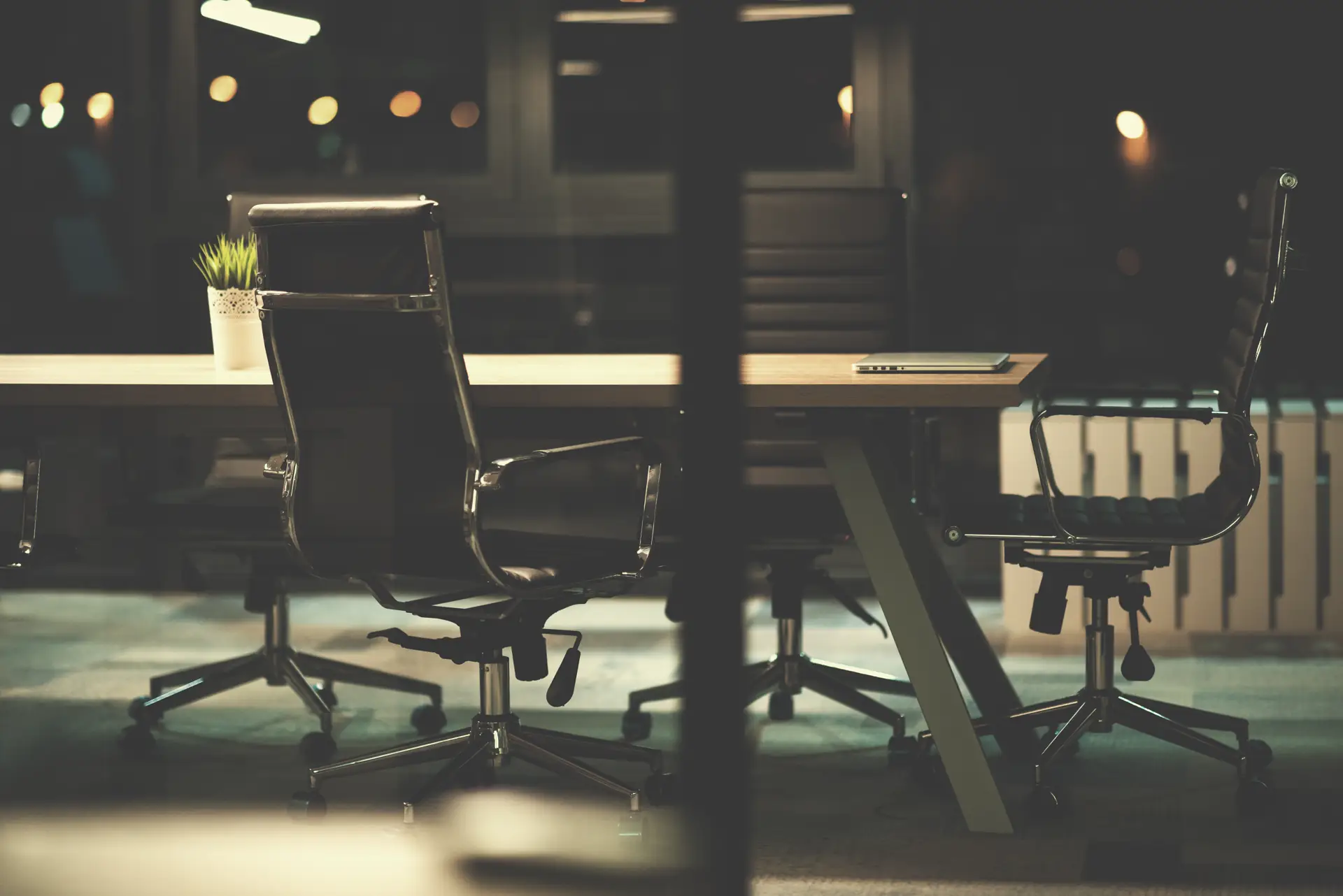 An empty boardroom at night, the seat still to be filled